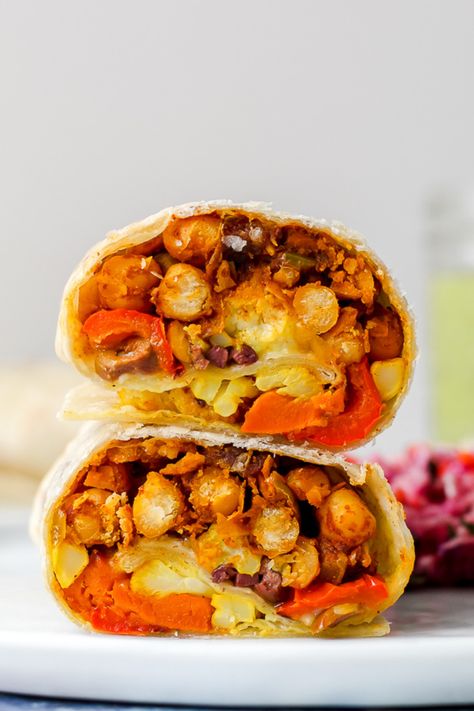 Moroccan chickpea burritos feature Moroccan-spiced chickpeas, turmeric-roasted cauliflower, roasted sweet potatoes, and peppers, feta, and olives. The dipping sauce is a tahini, lemon, and herb sauce- it's a delicious vegetarian dinner that is nutrient-rich and super flavourful! Green Tahini Sauce, Chickpeas Roasted, Green Tahini, Moroccan Chickpea, Moroccan Vegetables, Spiced Chickpeas, Burritos Recipe, Roasted Vegetable, Weekend Meals