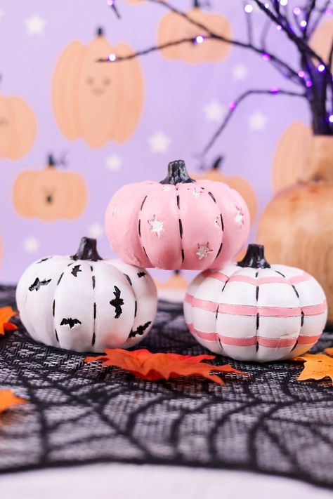 Add a touch of whimsy to your home with these 4" resin pumpkins. Available in 3 styles - white with black bats, white with pink stripes, or pink with white moons and stars - these pumpkins are perfect for your fall decor. Choose your favorite or mix and match for a unique look! Dimensions: 4 x 4 x 3" Pumpkin Decorations Ideas, Top Shelf Decor, Pastel Resin, Black Pumpkins, Pumpkin Idea, Overall Skirt Denim, Moons And Stars, Halloween Pumpkin Designs, Creative Pumpkins