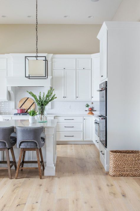 White Kitchen   White Oak Flooring   Fabric Bar Stools   Modern Kitchen   Tan Wall Paint   Box Pendant | Design by Scout Island Styling, Ruscus Greenery, Best White Paint Colors, Tan Walls, Italian Ruscus, Vintage Style Rugs, Light Hardwood, Best White Paint, Vanilla Milkshake