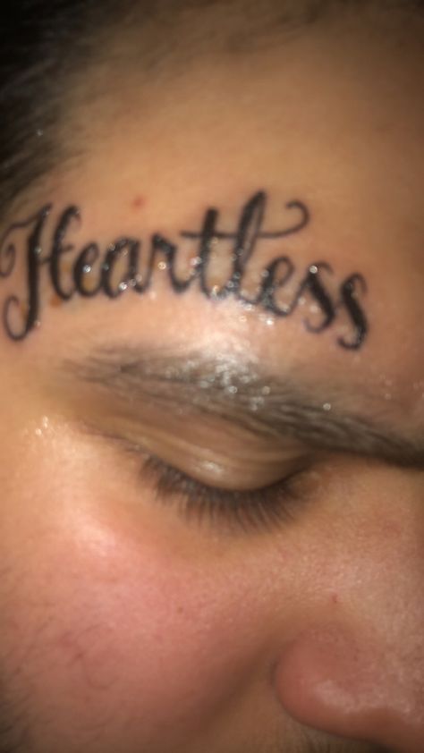 Heartless face tattoo Face Tats Men Small, Small Face Tattoo Men Under Eye, Face Tat Ideas, Word Face Tattoos, Easy Face Tattoos, Heartless Tattoo Men, Cute Small Face Tattoos For Women, Heartless Tattoo For Women, Face Tattoos For Women Eyebrow