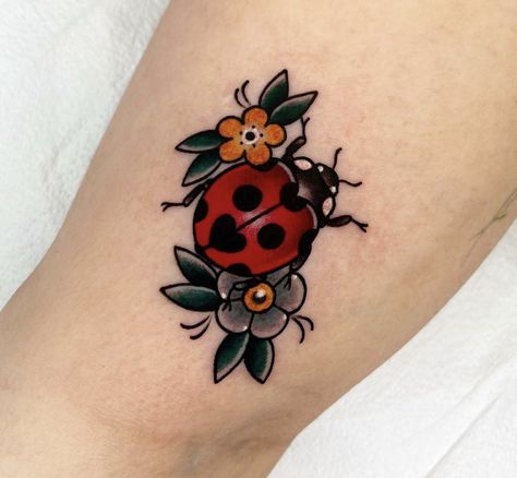 Pretty Tattoos Traditional, Traditional Style Ladybug Tattoo, Cute June Bug Tattoo, Old School Ladybug Tattoo, Traditional Greenery Tattoo, Traditional Ladybug Tattoo Black, Cute Bug Tattoos For Women, Ladybug With Flower Tattoo, Ladybug Tattoo American Traditional