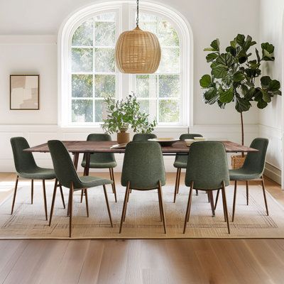 This 9-piece dining set is ready for get-togethers and other special occasions. It includes a rectangular table and eight side chairs. Each piece rests on angled, tapered metal legs for a sleek modern look, while the frame of the chairs and the table top are crafted from engineered wood with a brown finish. The chairs' seats and backs are wrapped in polyester and foam-filled for just the right amount of support as you enjoy casual meals or more formal dinners. Bonus: Multiple removable leaves co Olive Green Dining Room Chairs, Dining Room Green Velvet Chairs, Green And Wood Dining Table, Green Dining Chairs Wood Table, Green Chairs Dining Room, Natural Modern Dining Room, Craftsman Dining Room Decor, Beige And Green Dining Room, Green Accent Dining Room