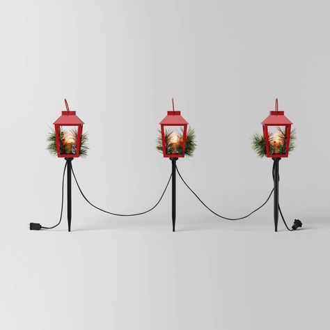 Light up your home for Christmas with this 3-Piece Incandescent Red Metal Lantern with Greenery Christmas Novelty Path Lights from Wondershop™. This set of path lights includes three bright red metal lanterns that are decorated with faux pine greenery for festive charm. It comes equipped with three clear light bulbs in a vintage shape with a flickering effect to cast a sparkling glow. The ground stakes allow for easy placement, and the end-to-end connector allows you to connect multiple light sets. Welcome to the Wondershop™. Christmas Yard Inspiration, Backyard Patio Christmas Decor, Red And White Outdoor Christmas Lights, Classic Christmas Outdoor Decor, Outdoor Christmas Decorations Yard Lights, Simple Outdoor Christmas Lights, Christmas Decor Outside Yard Decorations, Farmhouse Outdoor Christmas Decor, Christmas Lawn Decorations Front Yards