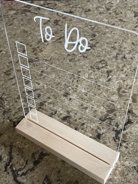 "This listing is for a clear acrylic dry erase to do list. Cut from 1/8\" clear acrylic. Words and lines are engraved on the backside for easy cleaning! Measures 7\" wide x 8 3/4\" tall with rounded corners. Available with or without wooden stand - see drop down menu. Looking for a custom acrylic sign? Message us for custom orders and pricing." Hanging Acrylic Sign On Wall, Acrylic Signs With Cricut, Laser Engrave On Acrylic, Acrylic To Do List Board, Acrylic To Do Board, Circuit Acrylic Projects, Cricut Dry Erase Vinyl Ideas, Circut Projects Ideas To Sell, Cricut Acrylic Signs