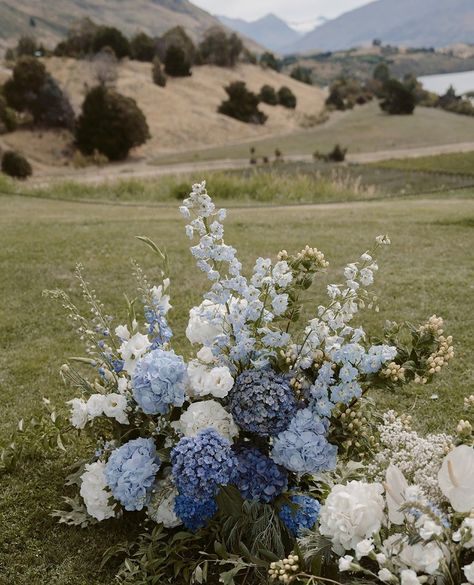 Winter blues, flowery hues   Stunners like these are here to prove that even in the coldest of days, beauty still blooms. ❄️💐 A wee festive feast for your eyeballs.  Forget about the winter blues and head over to our wedding blog for some epic inspo   #WinterFlowerPower #winterblues #autumnwedding #rippon #wanakawedding #wanakaflorist #nzbride2025 #weddinginwanaka Blue Floral Bouquet Wedding, Fall Wedding Colors Dusty Blue, White Blue Green Flower Arrangements, Wedding Flowers Blues, Blue Fall Flower Arrangements, Shades Of Blue Wedding Flowers, Blue And Green Flower Bouquet, Blue Wildflower Wedding Theme, Blue And Green Flowers Wedding