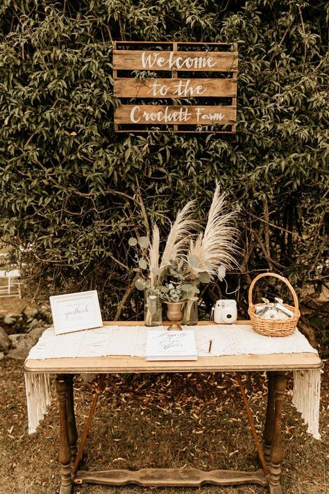 This rustic + boho welcome table features pampas grass and greenery floral pieces | Image by Maya Lora Photo Boho Wedding Signing Table, Boho Guestbook Table, Boho Card Table Wedding, Boho Wedding Guest Book Table, Boho Guest Book Table, Rustic Wedding Entry Table, Boho Guest Table Wedding, Boho Welcome Table, Boho Memory Table Wedding