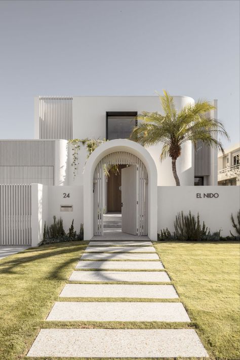 This Mediterranean inspired home features a paved footpath leading to a grand arch door entrance. Arch Door Entrance, Wabi Sabi Exterior, Brushed Nickel Tapware, Nickel Tapware, Taj Mahal Quartzite Countertops, Abi Interiors, Mediterranean Homes Exterior, Arch Door, Taj Mahal Quartzite