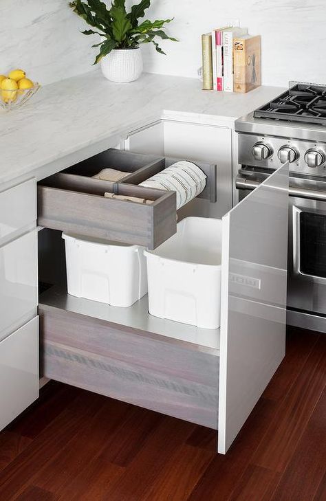 Beautiful white kitchen features white lacquered kitchen cabinets boasting a custom waste drawer fitted with dual trash cans positioned beneath a custom paper towel holder. Integrated Paper Towel Holder, Kitchen Cabinet Paper Towel Holder, Paper Towel Holder Above Trash Can, Paper Towel In Drawer, Rubish Ideas Kitchen, Garbage Drawer Kitchen, Cool Cabinet Features, Kitchen Trash Drawer, White Lacquer Kitchen Cabinets