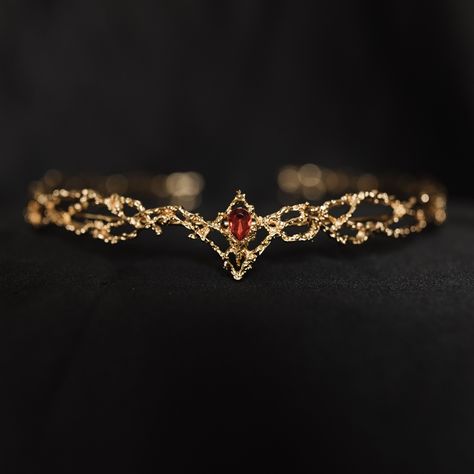 King's Crown features a beautiful gold colored metal braid formed into a circle highlighted by a red crystal at the center of the forehead. King's crown is tapered to fit just right and add the perfect touch.  Circumference: 6.5 Inches Height of Center: 1.25 Inches Ring Height: 0.25 Inches Crown is a disconnected circle and is adjustable to fit most hair styles and head shapes.  All items ship from Michigan, USA. WARNING: CHOKING HAZARD This item is not intended for use by children under the age of 5 years old.  There are small pieces that could fall off and create a choking hazard.  All use of this product by any minor, child or dependent should be supervised by an adult 18 years of age or older. Red Circlet Crown, Golden Circlet Crown, Gold Circlet Crown, Gold And Red Jewelry, Red And Gold Crown, Forehead Crown, Red And Gold Jewelry, Fantasy Crowns, Ruby Tiara