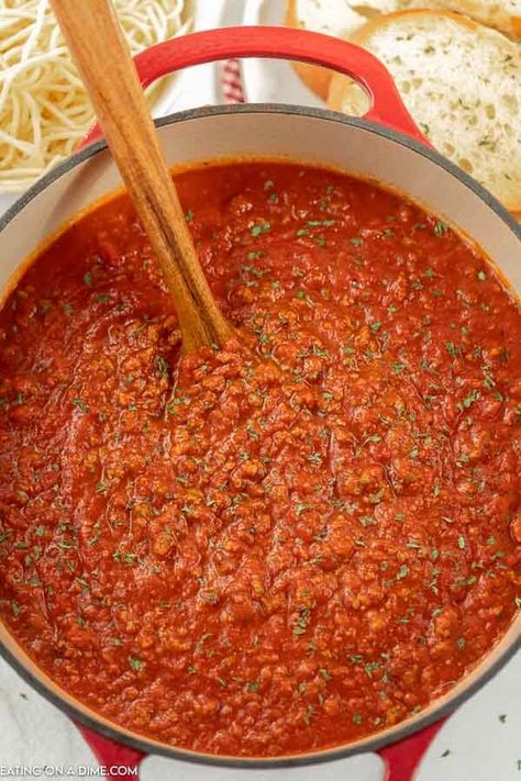 Close up image of spaghetti sauce in a dutch oven with a wooden spoon. Dutch Oven Spaghetti Meat Sauce, Dutch Oven Spaghetti Sauce, Oven Spaghetti Sauce, Freeze Spaghetti Sauce, Dutch Oven Spaghetti, Freeze Spaghetti, Bolognese Recipes, Pressure Cooker Spaghetti, Crockpot Spaghetti Sauce