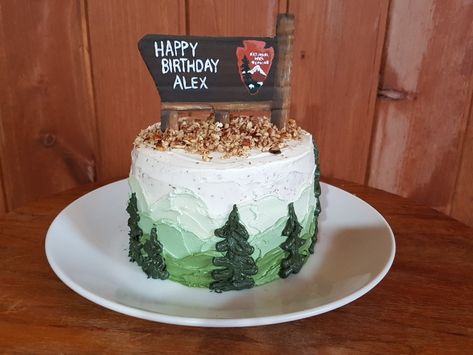 National Park Service wooden sign birthday cake with mountains and trees. Mountain Smash Cake, National Park Cake Ideas, Mountain 1st Birthday, National Parks Cake, Camp Smash Cake, Camping First Birthday Cake, National Park Cupcakes, National Park Birthday Cake, Nature Cakes Birthday