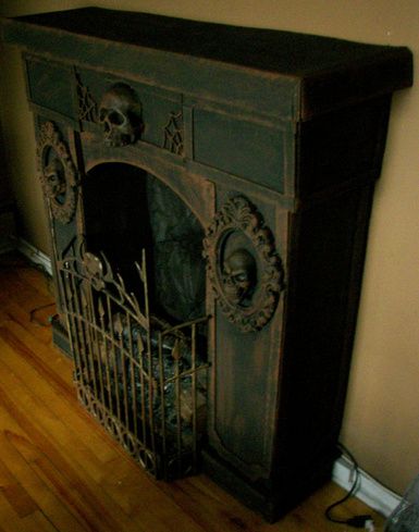 Faux fireplace ~ Crafted from cardboard and Dollar Store items - from halloweenforum Cardboard Fireplace Halloween, Faux Halloween Fireplace, Card Board Fireplace, Halloween Grandfather Clock Diy, Cardboard Box Halloween Decor, Diy Fake Fireplace Cardboard, Creepy Fireplace, Halloween Cardboard Crafts, Diy Halloween Fireplace