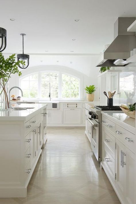 White+kitchen+features+creamy+white+shaker+cabinets+paired+with+white+quartz+countertops+and+a+... No Upper Cabinets, Kitchen Sink Window, Kitchen New York, Fresh Kitchen, All White Kitchen, Contemporary Cottage, Shaker Cabinets, Kitchen Features, Elegant Kitchens