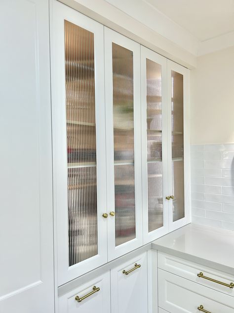 Custom designed fluted glass appliance cabinet, constructed in a timber grain Lamiwood with recessed LED strip lighting. Fitted with bi-fold opening doors and a 40mm stone benchtop. #kitchensbyemanuel #customjoinery #appliancecabinet #storagegoals Reeded Glass Cabinet Doors, Fluted Glass Cabinet Door, Fluted Glass Cabinets Kitchen, Fluted Glass Door Kitchen Cabinets, Bifold Kitchen Cabinet Doors, Fluted Glass Kitchen Cabinets, Glasses Cupboard, Recessed Led Strip Lighting, Fluted Glass Cabinet