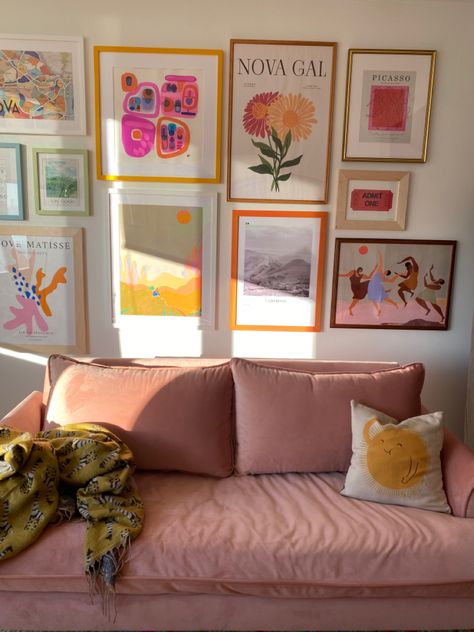 Gallery wall of bright colorful prints with a pink sofa featured Gallery Wall Bright Colors, Fun Living Room Wall Decor, Picture Wall Ideas Colorful, Colorful Picture Frame Gallery Wall, Gallery Wall College Apartment, Bedroom Inspirations Pink Walls, Gallery Wall Pastel, Colorful Collage Wall, Colored Frames On Wall