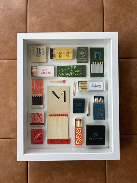 Custom Matchbook Shadowbox White Shadowbox  -American Flat Frame -12 inches wide -15 inches tall -2.5 inches thick Featuring a mix of vintage matchbooks and trendy restaurants! -Nick & Toni's  -Calicoon Hills -The Hotel Chelsea -Cafe Spaghetti -Misi -Manhatta -Liberty Bistro -Bar Primi -Bad Roman -Harry's Wall Street -Casa Cipriani -Gage & Tollner -Vintage Matchbook - The Chatter Box New Lexington Shadowbox Matches, Diy Matchbook Art, Matchbox Shadow Frame, Souvenir Box Ideas, Vintage Diy Gifts, Match Box Collage, Display Matchbooks, Matchbook Shadow Box Art, Match Book Art