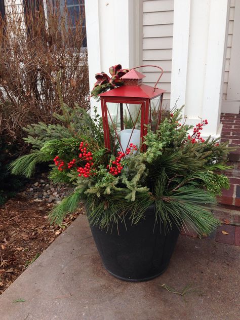 Outdoor Planters For Winter, Outdoor Planters With Lanterns, Classy Yard Christmas Decorations, Front Porch Christmas Decor Ideas Diy Pots & Planters, Christmas Planters With Lanterns, Christmas Planter With Lantern, Winter Porch Planters, Lantern Planter Ideas, Christmas Pots Outside Front Porches