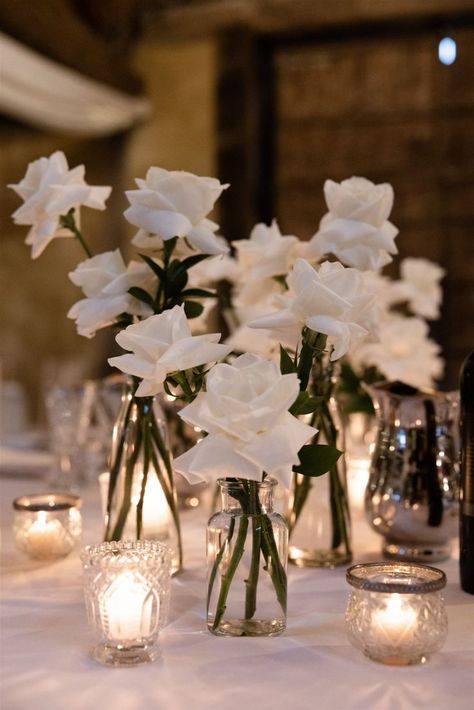 Wedding white roses Flower On Table Wedding, White Rose Candle Centerpiece Wedding, Wedding Flower Vases Reception Ideas, Spring Modern Wedding, White Roses In Bud Vases Wedding, Simple White Rose Table Decor, White Rose Wedding Reception, Roses In Bud Vases Wedding, Bud Vases Roses