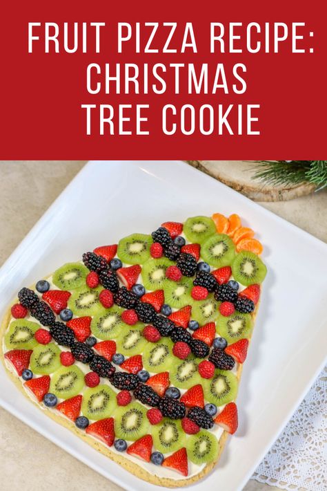 This Christmas Tree Cookie Fruit Pizza Recipe is exactly what you need this holiday season. Easy to make and serve, this #recipe is perfect for any occasion Christmas Fruit Pizza Ideas, Holiday Fruit Pizza, Christmas Tree Fruit Pizza, Fruit Cookie Pizza, Christmas Fruit Ideas, Christmas Tree Pizza Appetizers, Christmas Fruit Pizza, Fruit Pizza Sugar Cookie Christmas, Sugar Cookie Fruit Pizza