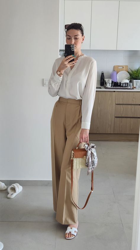 White blouse with long sleeve, beige high waist long pants, Hermes white slippers, Burberry brown sunglasses, summer outfit work office 2023 White Pants And Brown Top Outfit, White Blouse Formal Outfit, Cream Shirt Outfit Women Work, Khaki Office Pants Outfit, How To Style Beige Formal Pants, White Top Beige Pants, Silk Fit Pants, Brown Top Outfit Work, Beige Silk Shirt Outfit