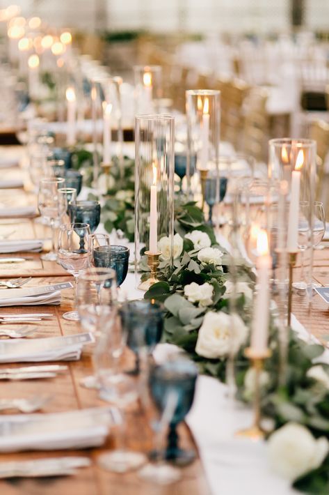 Greenery garland with pops of white flowers for long farm table centerpiece. Taper candles to accent. Captured by Gabby for Emily Wren Photography https://emilywrenweddings.com/ Candle Chimney Wedding, Farm Table Garland Wedding, White Long Table Centerpiece, Farm Table Wedding Decor Candles, Taper Candles Long Table Wedding, Centerpieces Wedding Farm Table, Candle Long Table Centerpiece, Wedding Table With Taper Candles, White Flowers Candles Wedding