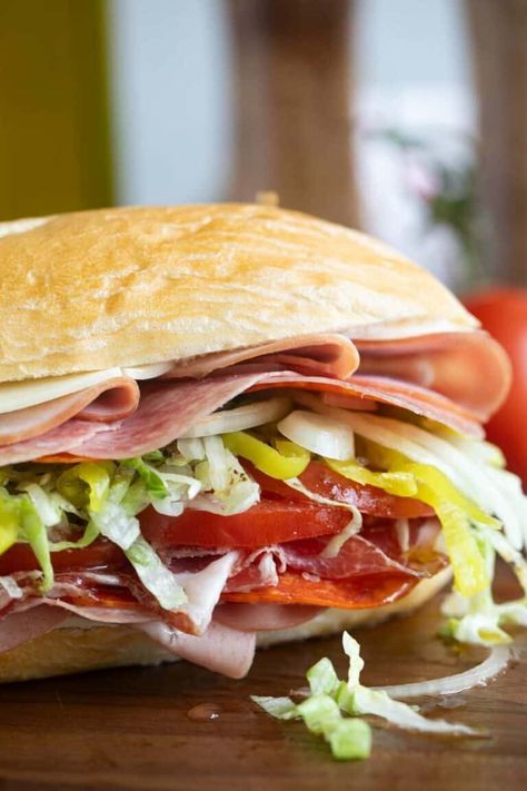 Filled with cheese and lots of Italian meats, skip the sandwich shop and make this Italian Sub recipe at home! This is the perfect sandwich for and easy dinner at home. Mini Italian Subs, Dressing For Italian Subs, Hoagie Sandwich Ideas, Italian Combo Sandwich Recipe, Baked Italian Subs, Baked Italian Sub Sandwich, Italian Subs Sandwich, Sub Sandwiches Ideas, Cold Sub Sandwich Ideas