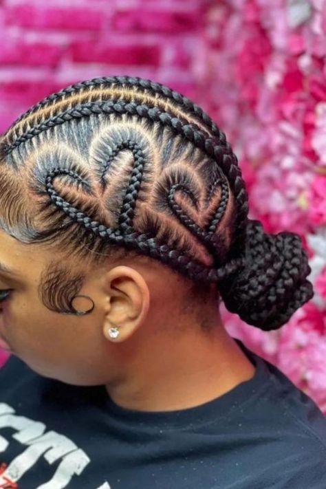 Low Braided Bun With Heart-Shaped Braid Designs Cornrow Hairstyles With Heart Design, Cornrows Braids For Black Women Heart, Cornrow With Designs, Hairstyle Braid Ideas, Heart Hair Braids, 2 Braids With Heart, Cornrow Hairstyles With Bun, Two Braids In A Bun, Heart Braids Black Women