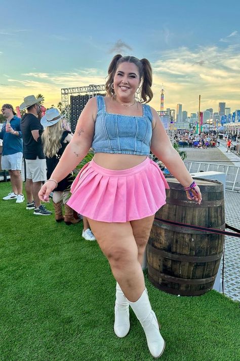 A smiling woman poses outdoors at a festival, wearing a denim crop top, a pink pleated skirt, and white boots. Her hair is styled in playful pigtails, and behind her, people are mingling against a backdrop of a vibrant city skyline and amusement rides at sunset Cowgirl Boots, Miami, Country Music, Festival Vibes, The Hook, Stop Thinking, Music Festival, The Incredibles