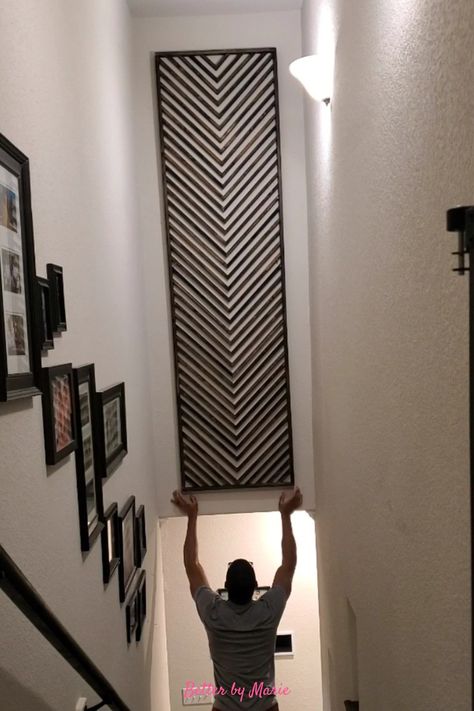 Wooden DIY artwork with herringbone pattern Stairwell Wall Ideas Basement, Black Wall Stairs, Tiled Staircase Wall, Diy Stair Wall Decor, Downstairs Wall Ideas, Unique Staircase Wall Decor, Stairwell Wall Art Ideas, Staircase Large Wall Decor, Tall Stairway Decorating