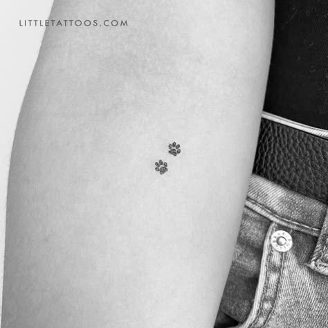 Set of three minimalist tiny pet paw print couple temporary tattoos. Paw print tattoos are a popular motif that can be chosen for a variety of reasons. Regardless of your reason for considering this type of tattoo, our dog paw print pair temporary tattoo offers you the ideal way to try before you buy. Our eco-friendly two pawprints fake tattoo features two tiny canine dog prints in black soy-based ink. With its small size, this is a design that will fit anywhere on your body. Don’t worry, you ge Tattoos Honoring Pets, Dog Tattoo Designs For Women, Puppy Paw Tattoo Small, Small Tattoos For Pets, Tiny Paw Print Tattoo Cats, Two Paw Print Tattoo, Dog Mini Tattoo, Tiny Paw Tattoo, Minimalistic Animal Tattoo