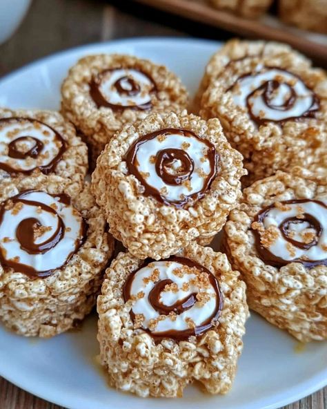 🍫 S'mores Rice Krispies Treats Pinwheels 🍫 These S'mores Rice Krispies Treats Pinwheels are a fun twist on the classic treat, combining the flavors of s'mores into a delightful rolled-up snack! Ingredients: 3 tablespoons unsalted butter 1 package (10 oz) mini marshmallows 6 cups Rice Krispies cereal 1 cup graham cracker crumbs 1 ½ cups mini chocolate chips 1 jar (7 oz) marshmallow fluff Instructions: Prepare the Pan: Line a large baking sheet with parchment paper. Make the Rice Krispies ... Rice Krispies Cereal, Rice Krispies Treats, Krispies Treats, Marshmallow Fluff, Rice Krispie Treats, Rice Krispie, Mini Marshmallows, Cute Desserts, Graham Cracker Crumbs