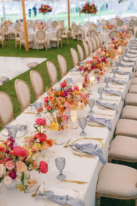 |NK Wedding Planning. Get in touch with us today.| Bay Preserve Wedding, outside wedding, tented wedding, floral centerpieces, pink, blue, orange, roses, gold, blue napkins, gold silverware, louis chair natural, ~Taken by Hunter Ryan Photo~ Wedding Tables Lay Out, Wedding Lots Of Flowers, Vogue Wedding Tablescape, Diy Wedding Tablescapes, Slate Blue And Pink Wedding, Pink And Orange Wedding Palette, November Garden Wedding, Red Orange Pink Blue Wedding, Bright Summer Wedding Table Decor