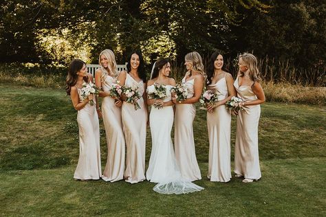 Bridal party in champagne gold satin bridesmaid dresses with the bride in a Halfpenny London wedding dress Bridesmaid Gold Satin Dress, Bridesmaid Dresses Satin Champagne, Ivory Silk Bridesmaid Dresses, Cream Wedding Bridesmaid Dresses, Chiffon And Satin Bridesmaid Dress, Bridal Party Photos Champagne, Soft Gold Bridesmaid Dresses, Bridal Party In Champagne, Champagne Gold Bridesmaid Dresses Color Schemes