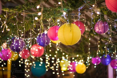 Village hall wedding - paper lanterns - colourful wedding decorations - fairy lights. What a fabulous wa to light up your wedding!  www.amyjamesphotography.co.uk Wedding Lantern Decor Fairy Lights, Paper Lanterns Outdoor Party, Party Lanterns Decor, Decorating A Hall For A Party, Colorful Prom Theme, Festival Garden Party Decoration, Lanterns Birthday Decor, Festival Theme Decorations, Coloured Lanterns Wedding