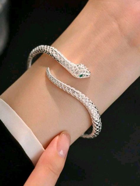 Unleash your inner serpent with this Adjustable Silver Snake Bangle! Featuring a sleek, coiled design that wraps gracefully around your wrist, this bangle symbolizes transformation and power. Its adjustable fit ensures it slips comfortably onto any wrist, making it a versatile accessory for any outfit or occasion. Whether you're drawn to its bold, edgy look or its deeper symbolism of rebirth and resilience, this snake bangle is a statement piece that commands attention. Embrace your unique style and let this serpent be a stylish reminder of your strength and evolution. Make it yours today! Ouroboros Bracelet, Ouroboros Jewelry, Cool Bracelets, Chunky Silver Bracelet, Gifts For Young Women, Silver Snake Bracelet, Snake Bangle, Serpent Jewelry, Bracelet Trendy