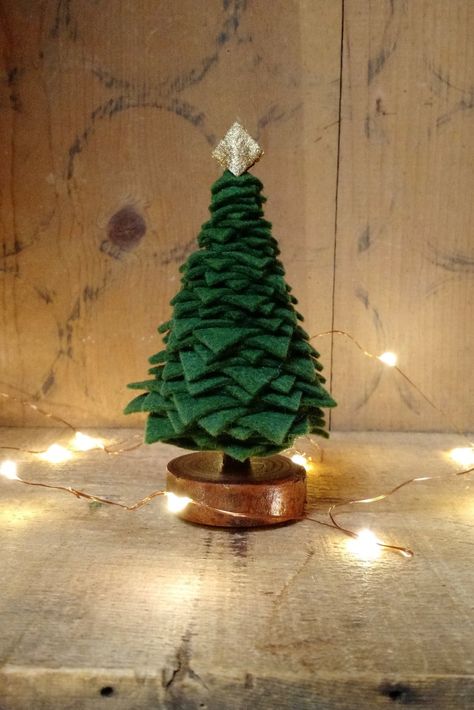 "This cute little tree will be the perfect addition to your holiday scenes, home decor, dollhouse or indoor fairy garden.  Made from a high quality would blend felt in Dark (Christmas Tree) green it sits atop a hand finished hardwood base with a gold \"star\" on top.  Height is 5\" from tip of star to base.  Width at widest part of tree is 3\".   Each item is handmade so slight variations may occur. Pieces of felt can be spun to change the pattern. Want to send this item directly to the recipien Dark Christmas Tree, Wool Christmas Tree, Maileg Christmas, Elegant Holiday Decor, Primitive Christmas Tree, Diy Felt Christmas Tree, Christmas Tree Green, Felt Tree, Dark Christmas