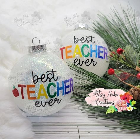 Spread cheer this holiday season by gifting your favorite teacher the Best Teacher Ever Christmas Ornament! Crafted with great attention to detail, this ornament celebrates the amazing efforts of teachers -- making a lasting impression on those who give and receive. Show your appreciation and make a statement with this special gift! 3" Glass Ornament Permanent vinyl lettering Comes with a white gift box This beautiful ornament uses 8 or or 9 colors for the vinyl on the outside, depending on opti Work Xmas Gift Ideas, Glitter Christmas Ornaments With Vinyl, Christmas Fillable Ornaments, Christmas Ornament Vinyl, Christmas Crafts To Gift, Christmas Teacher Gifts Cricut, Personalized Glitter Ornaments, Cricut Ornament Ideas Easy Diy, Gift For Teacher Christmas