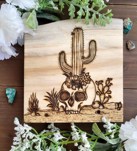 Wood burned piece featuring hand drawn skull with cactus and flowers on Aspen wood from Colorado. . . . 6.5 in by 6 in Cactus Wood Burning, Cactus And Flowers, Drawn Skull, Burning Flowers, Wood Burned Signs, Aspen Wood, Easy Minecraft Houses, Wood Burning Art, Desert Landscape