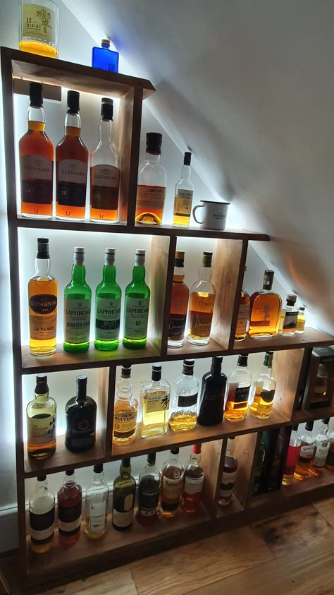 Back-lit shelving behind a glass screen under stairs Liquor Closet Under Stairs, Under Stairs Whisky Storage, Under Stairs Alcohol Storage, Alcohol Pantry, Under Stairs Bourbon Storage, Whiskey Closet, Whisky Shelves, Bar Under Staircase, Under Stairs Bar Ideas