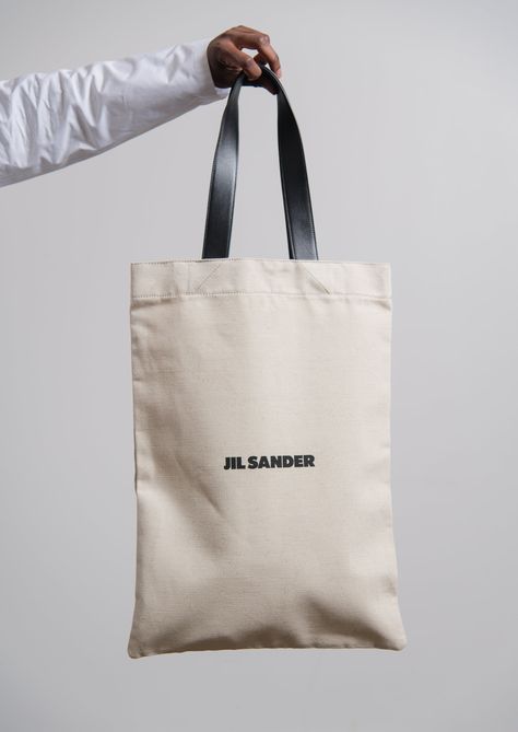 Cotton-linen blend canvas shopper bag in Natural Double buffed leather handles Printed Jil Sander branding at front Buffed leather inner pocket Made in Italy 70% cotton, 30% linen body 100% calf leather handles Jil Sander Canvas Bag, Leather Shopping Bag, Designer Canvas Tote Bag, Cotton Bag Design, Shopper Bag Design, Tote Bag Packaging, Canvas Tote Bag Design, Eco Bag Design, Branded Shopping Bags