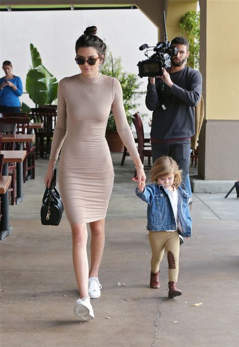 While spending the day with her niece Penelope, Jenner keeps it chic in the ultimate naked dressing staple: a flesh-toned bodycon dress. She offsets  the sexy for daytime pairing it with a messy bun and trainers.    - MarieClaire.com Black Bodycon Dress Outfit, Kendall Ve Kylie, Mode Kylie Jenner, Kendall Jenner Street Style, Body Con Dress Outfit, Kendall Style, Walking Down The Street, Kendall Jenner Outfits, Jenner Outfits