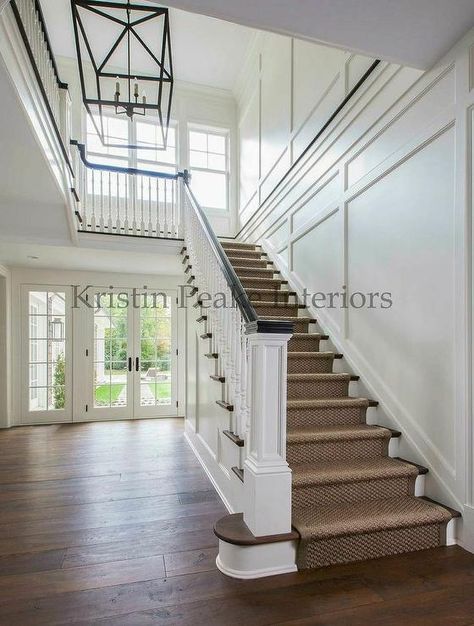 Transitional two story foyer features a lantern illuminating a staircase lined with a bound sisal ... Foyer Lighting Fixtures Entryway, Wainscoting Stairs, Foyer Staircase, Wainscoting Styles, Foyer Lighting Fixtures, Flooring For Stairs, Entry Stairs, Exterior Stairs, Stairs Architecture