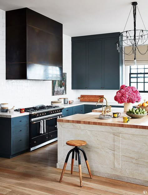 In the kitchen a darkened brass hood hangs over a Lacanche range. Cabinets painted in Farrow  Ball's down pipe. Brass Hood, Lacanche Range, La Kitchen, Celebrity Kitchens, Clements Design, Oven Hood, Laundry Room Flooring, Los Angeles Homes, Jackson Hole