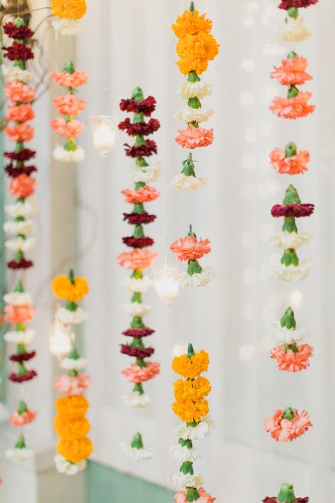 Draped over the table, swagged around the ceiling or lined up together like a curtain, flower garlands are everywhere. (Searches for flower garland +1154%) Indian Wedding Florals, Carnation Decor, Carnation Garland, Indian Decoration, Flowers Hanging, Backdrop Photography, Indian Inspired, Indian Decor, Floral Decoration