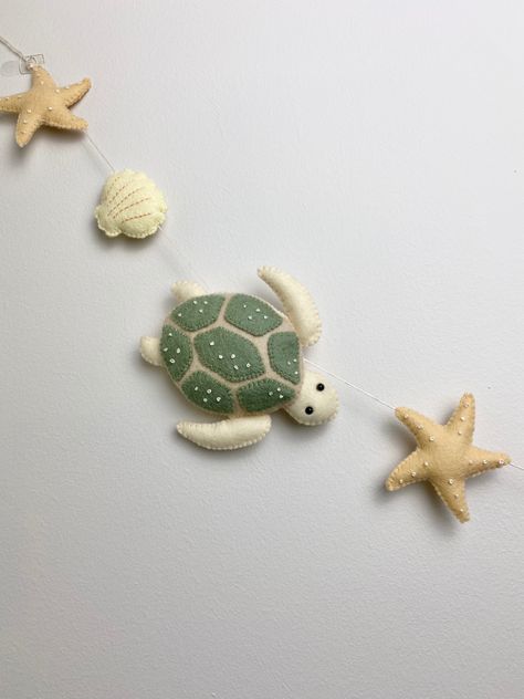 Felt turtle, starfish and sea shell garland , perfect for childs room/ nursery. Beautiful hung along a babies crib, along a bookshelf, or windowsill. The possibilities are endless! Length is approximately 53 inches with extra for hanging. Felt Starfish, Felted Turtle, Felt Garland Nursery, Sea Turtle Nursery, Turtle Room, Sea Life Nursery, Felt Turtle, Summer Garland, Turtle Nursery