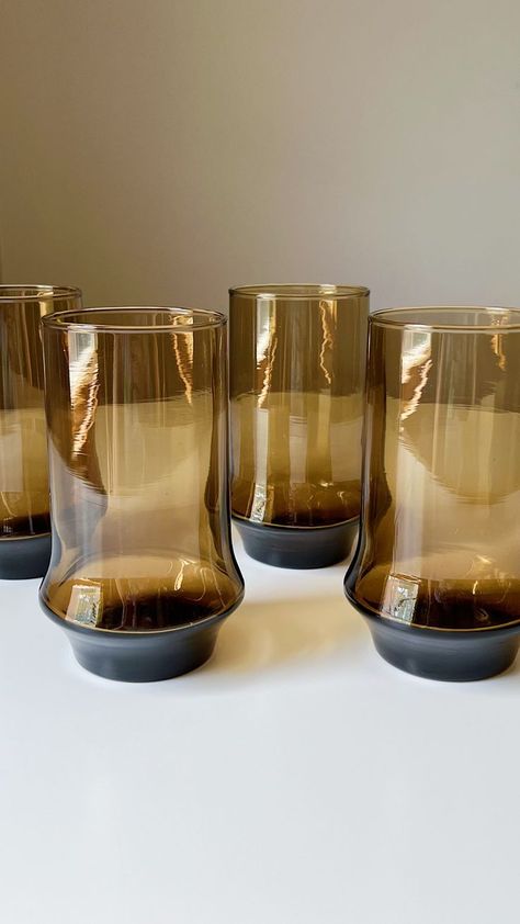 These brown smoked glasses embody the allure and style of the 1970s. The vintage design of these tumblers features sleek lines and a slightly flared shape which exudes an understated elegance that never goes out of style. Whether you're hosting a retro-themed party or simply looking to add a touch of vintage sophistication to your drink collection, these tumblers are sure to impress your guests and transport them back in time. Product Details Year: 1970s Capacity: 16 fluid ounces 70s Dishware, 1970s Glassware, Brown Glassware, Retro Glassware, Glasses Vintage, Understated Elegance, Vintage Glassware, Back In Time, Themed Party