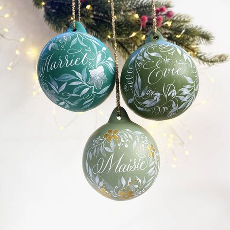 These gorgeous green baubles are a perfect keepsake and can be personalised with a name of your choice! Ceramic bauble hand painted with any name, and in a choice of 3 glorious greens!The price shown is per bauble Choose from three colours:Harriet: Winter green with silver flowersEvie: Olive green with snowdrop illustrationMaisie: Sage green with gold flowers Ceramic bauble, paints and calligraphy inks, varnish Personalised Ornaments Christmas, First Christmas Bauble, Snowdrop Illustration, Hand Painted Baubles, Painted Baubles, Hand Painted Bauble, Flowers Ceramic, Winter Green, Crochet Christmas Decorations