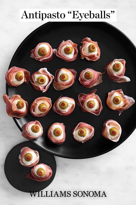 These spooky eyeballs peer at Halloween party guests, but don’t worry—they are harmless and taste delicious! This no-recipe recipe is a super-easy way to celebrate that most frightful of holidays while serving everyone an elevated spread of cheese, olives and prosciutto. Halloween Caprese Eyeballs, Scary Veggie Tray, Eyeball Caprese Bites, Halloween Antipasto Eyeballs, Spooky Vegetable Tray, Halloween Bites Ideas, Olive Stuffed Eyeballs, Prosciutto Skull Head, Mozzarella Eyeballs Halloween Party