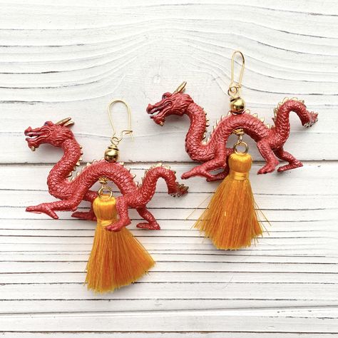 2024 is the Year of the Dragon.🐉 Celebrate the Lunar New Year in style with these powerful Year of the Dragon earrings. The rich gold and deep red tones of these Chinese New Year inspired statement earrings represent joy and good fortune. Resin dragons and stunning silky tassels create these dynamic dragon earrings that are ready to turn heads and celebrate the New Year in style. Gold-plated, nickel-free ear wires. May 2024 bring you happiness and wealth! Dragon Earrings, Alphabet Beads, Bird Necklace, Year Of The Dragon, Red Dragon, Lunar New Year, Purse Charms, Good Fortune, Lunar New