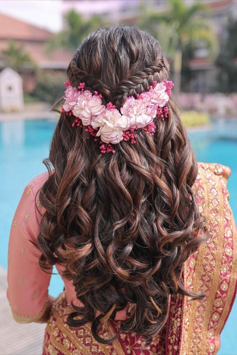 Channel your inner flower goddess with this ethereal bridal hairstyle! Cascading curls meet meticulously crafted braids, all adorned with the softest pink blooms. A Mehendi look can fall into the 'attention-worthy' category only when all these elements are well thought of - outfit, makeup, and hair. And with everything about experimentation, why to forget about the unique hairstyles that you can explore! Hair Style On Saree, Hair Colour Design, Half Updo Hairstyles, Hair Style Vedio, Hairstyles Design, Sophisticated Hairstyles, Engagement Hairstyles, Hair Color Underneath, Traditional Hairstyle